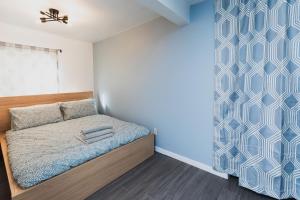 Dormitorio pequeño con cama y pared en Avenir Centre Suite en Moncton