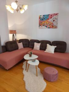 Apartments Zvonimir في هفار: غرفة معيشة بها كنبتين حمراء وطاولة