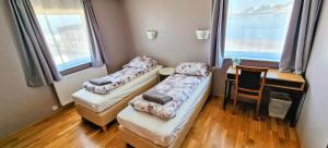 2 camas en una habitación con mesa y ventana en Aurora Guesthouse en Grundarfjordur