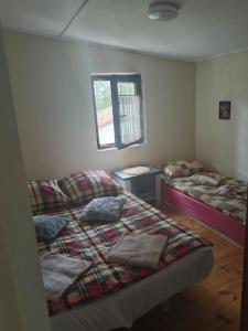 - une chambre avec 2 lits et une fenêtre dans l'établissement Domek w sercu lasu w Borach Tucholskich, à Ocypel