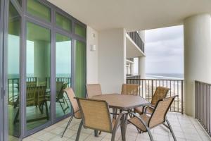 a balcony with a table and chairs and a table and a table at Oceanfront Orange Beach Condo with View and Pool! in Orange Beach