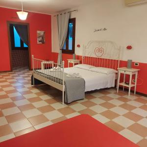 una camera con letto bianco e pareti rosse di Casa di Alice a Chioggia