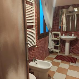 a bathroom with a white toilet and a sink at Casa di Alice in Chioggia