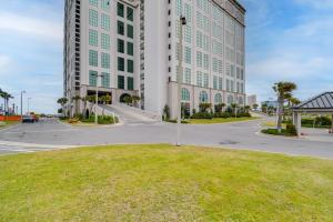 a large white building with a street in front of it at Oceanfront Orange Beach Condo with View and Pool! in Orange Beach
