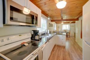 una cucina con armadi bianchi e soffitto in legno di Lakefront Getaway with Canoe and Dock Fishing! a Henniker