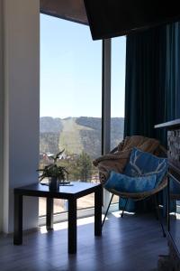 uma sala de estar com uma mesa, uma cadeira e uma janela em Vila Onyx em Divčibare