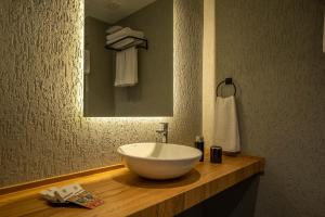 a bathroom with a large white bowl sink on a wooden counter at Gündoğan Suites in Bodrum City