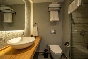 y baño con lavabo blanco y aseo. en Gündoğan Suites, en Bodrum City