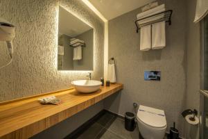 a bathroom with a sink and a toilet and a mirror at Gündoğan Suites in Bodrum City