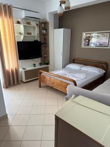 1 dormitorio con 1 cama y TV en una habitación en Eid Mar en Vlorë