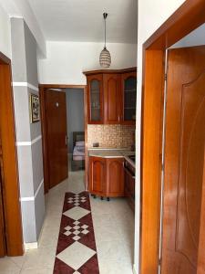 cocina con armarios de madera y suelo de baldosa en Eid Mar en Vlorë