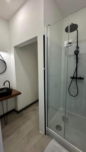 W łazience znajduje się prysznic ze szklanymi drzwiami. w obiekcie Au temps des pêcheurs Piscine chauffée w mieście Saint-Pierre