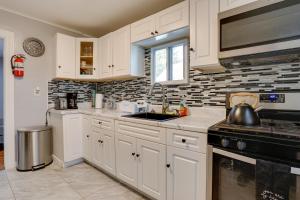 a kitchen with white cabinets and a sink at Cozy Condo about 11 Mi to Manhattan, Pets Welcome in Teaneck