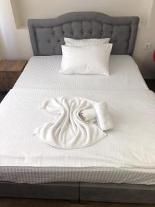 a bed with a white blanket and pillows on it at Eylül suit otel in Yıldırım