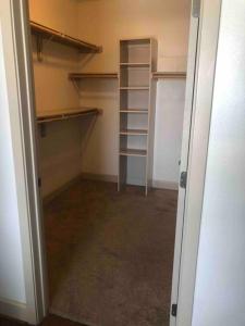 an empty walk in closet with empty shelves at BEAUTIFUL STUDIO 7MIN FROM THE GALLERIA MALL in Houston