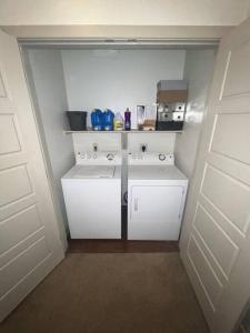 una pequeña cocina con armarios blancos en una habitación en BEAUTIFUL STUDIO 7MIN FROM THE GALLERIA MALL, en Houston