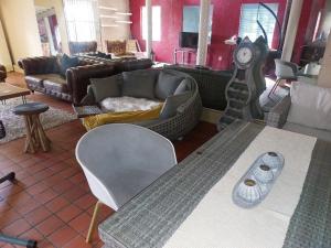 a living room with a couch and a clock at Gallery Guesthouse (La Sky Villa) in Gqeberha