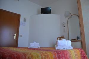 una camera con un letto e asciugamani di Hotel Apis a Rimini