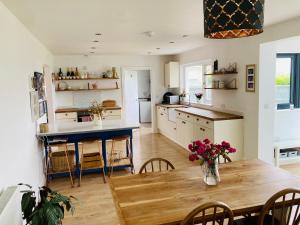 a kitchen and dining room with a wooden table at Beautiful 4-Bed House with countryside views in Haverfordwest