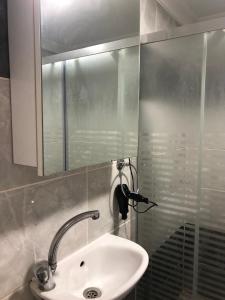 y baño con lavabo, espejo y ducha. en Eylül suit otel, en Yıldırım