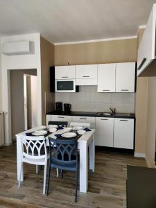 Una cocina con gabinetes blancos y una mesa y sillas. en Casa di Roby, en Rapallo