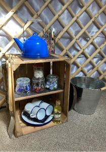 eine Holzkiste mit Teekanne und Essen in der Unterkunft Eisa Yurt in York