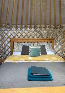 uma cama numa tenda com uma cabeceira de madeira em Eisa Yurt em York