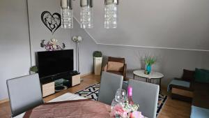 a living room with a dining table and a television at Apartament na Gryfa 8 in Stężyca
