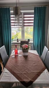 stół jadalny z 2 kieliszkami i butelką wina w obiekcie Apartament na Gryfa 8 w mieście Stężyca