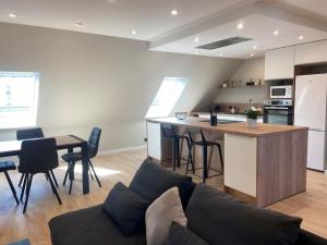 a kitchen and living room with a couch and a table at La perle Bayeusaine in Bayeux