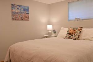 a bedroom with a white bed with a pillow and a window at UW Cozy - Quiet Home, Perfect for Family and Group in Seattle