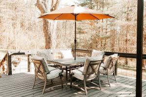 een tafel en stoelen met een parasol op een terras bij Luxury Mountain Getaway in Pickens