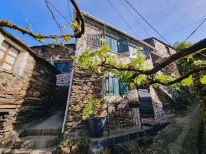 an old stone house with plants in front of it at Canastro Nature Spot in Viseu