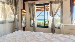 a bedroom with a bed and a view of the ocean at Chancabañita Tulum in Tulum