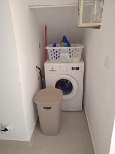 a laundry room with a washing machine and a trash can at Casetta capodimonte in Naples