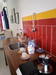 a kitchen with a sink and a counter with cups at Casetta capodimonte in Naples
