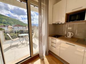a kitchen with a view of a balcony with a table at Palma in Budva
