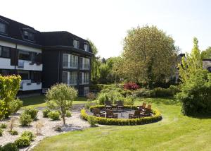 ein Haus mit einem Garten mit Stühlen und einem Tisch in der Unterkunft Hotel Lange in Leer