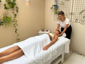 Eine Frau bekommt eine Massage von einem Mann auf einem Bett in der Unterkunft Parador Búzios Boutique Hotel in Búzios