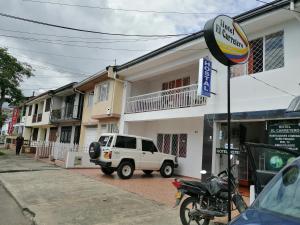 a white truck parked in front of a building at Hotel El Carretero in Popayan