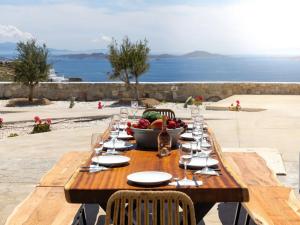una mesa de madera con un bol de fruta. en Stunning Oceanview Mykonos Villa | 5 Bedrooms | Villa Perseus | Amazing Location Overlooking Sea & Private Pool | Faros, en Fanari