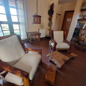 a living room with two chairs and a couch at Yanasuspa Huasin & Sol del Pilar in Tafí del Valle
