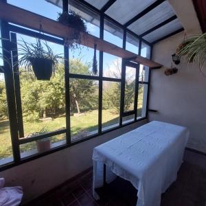 a room with a table and a large window at Yanasuspa Huasin & Sol del Pilar in Tafí del Valle