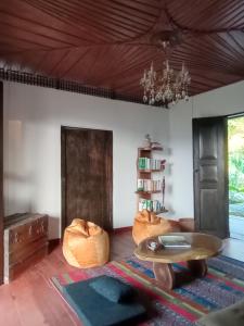 a living room with a table and a chandelier at Reserva Natural Zarandá in Pereira