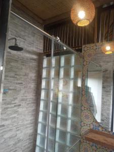 a bathroom with a glass shower with fish in it at Reserva Natural Zarandá in Pereira