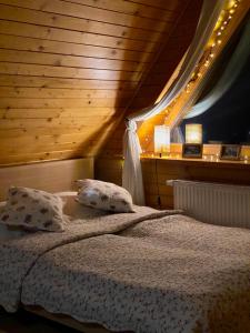 a bedroom with a bed with two pillows at Apartament Centrum Zakopane in Zakopane