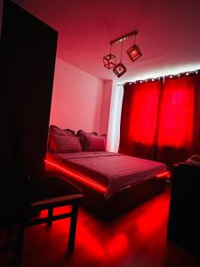 クラヨーヴァにあるApartament Promenadaのベッドルーム1室(赤い照明付きのベッド1台付)