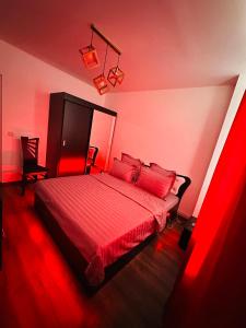 クラヨーヴァにあるApartament Promenadaの赤い照明付きのベッドが備わる赤いベッドルーム1室