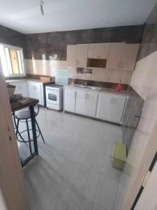 a kitchen with white cabinets and a table in it at DAR EL3EZ in Sicca Veneria