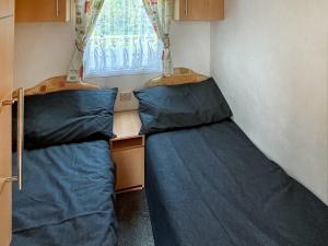 - 2 lits dans une petite chambre avec fenêtre dans l'établissement Carnaby - Uk47074, à South Chard
